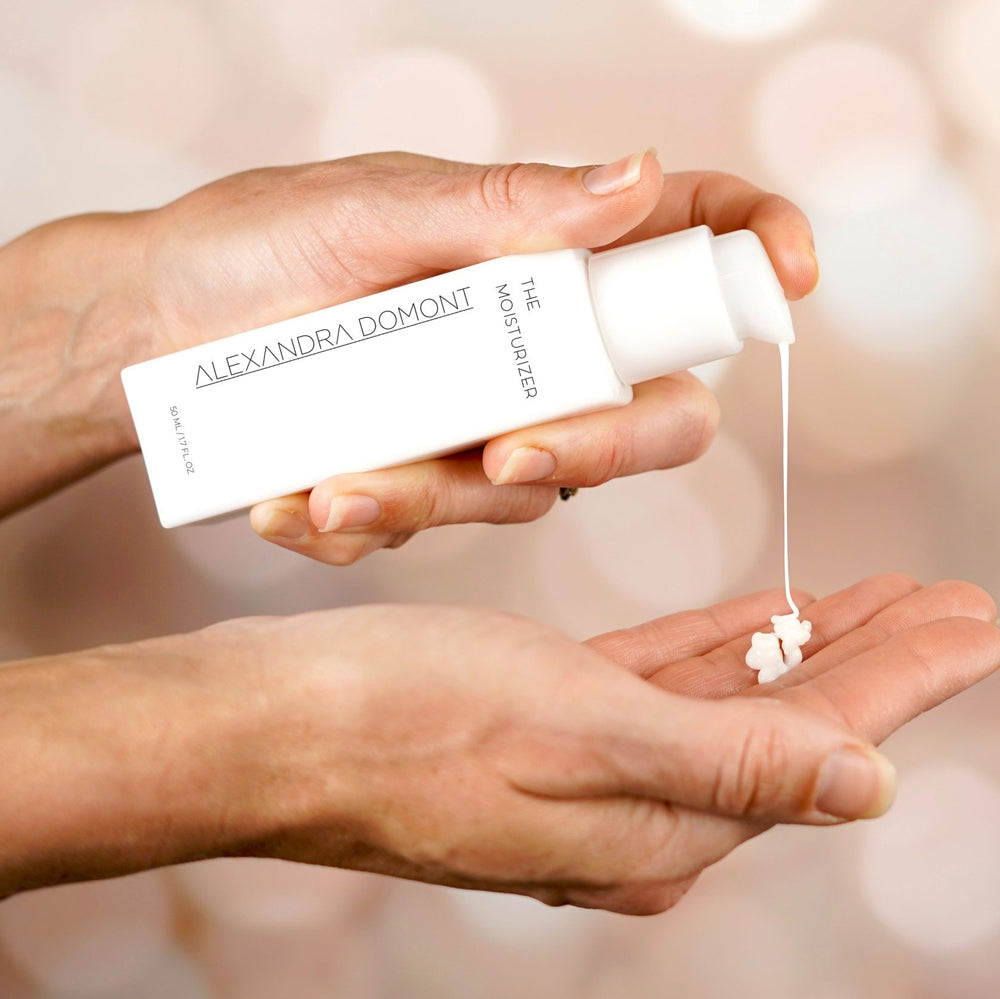 A hand dispenses white moisturizer onto a palm, set against a soft, blurred backdrop—emphasizing effortless order tracking.